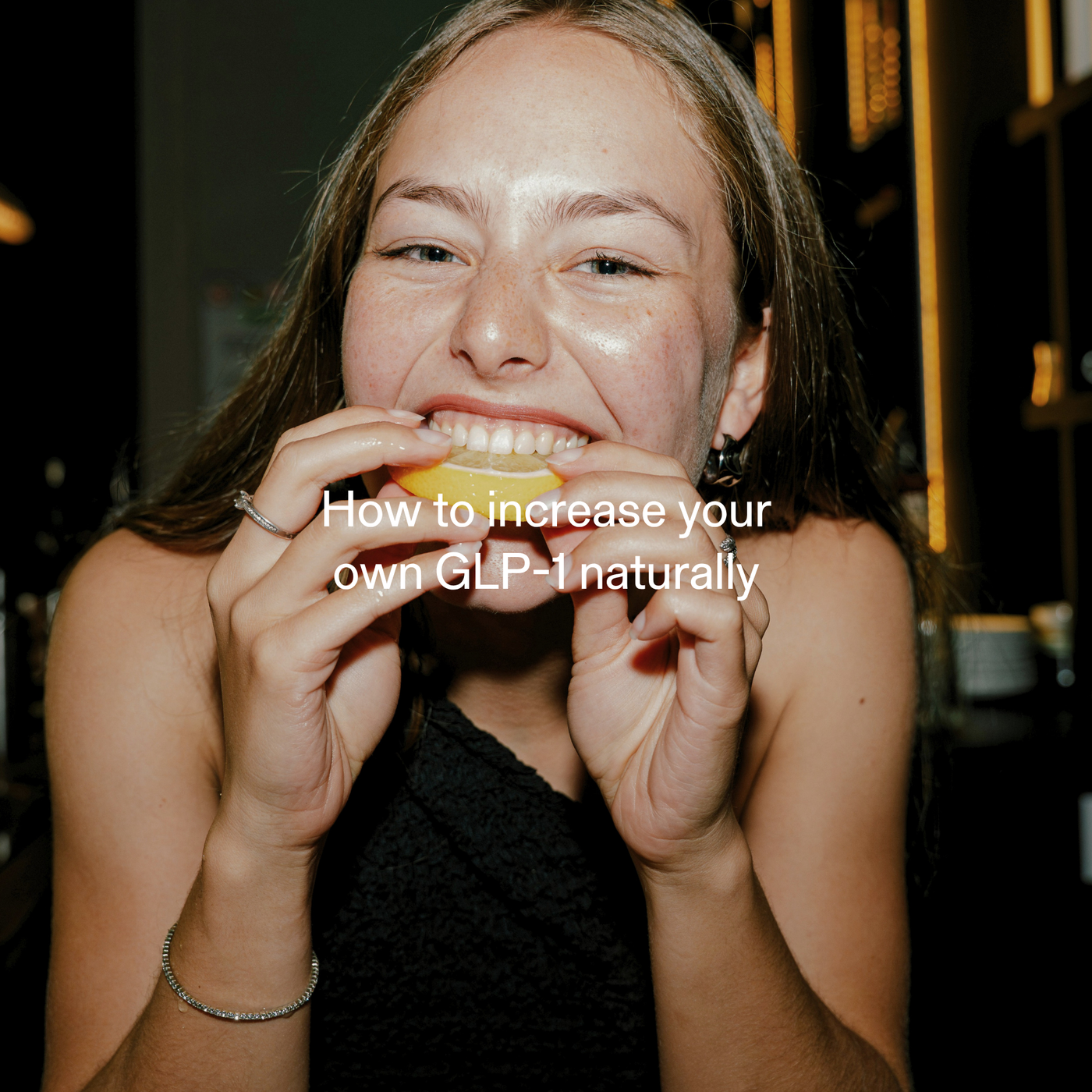 Young woman biting into a lemon slice to naturally boost GLP-1 levels for appetite control
