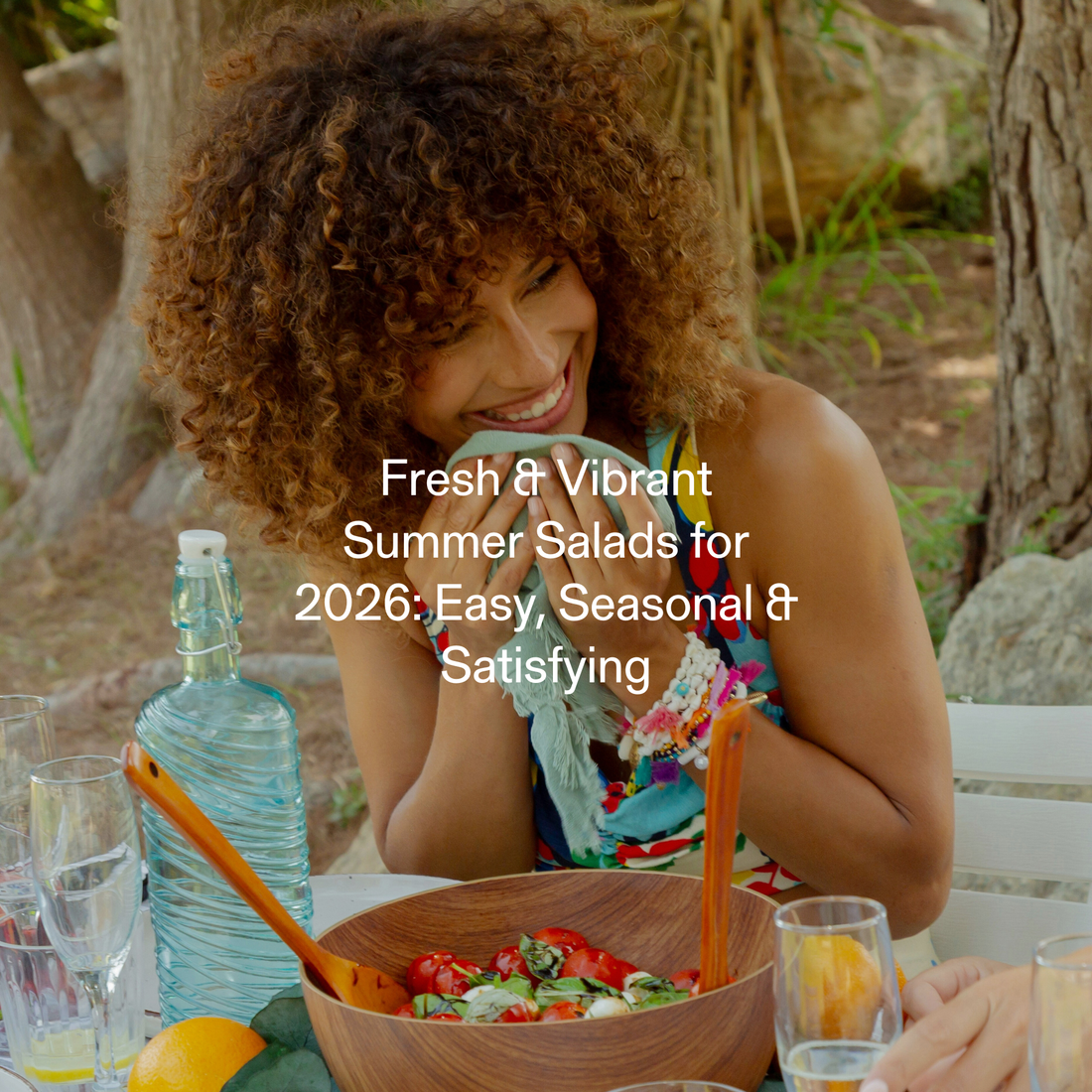 Smiling woman enjoying a summer salad outdoors with fresh seasonal ingredients and sparkling water
